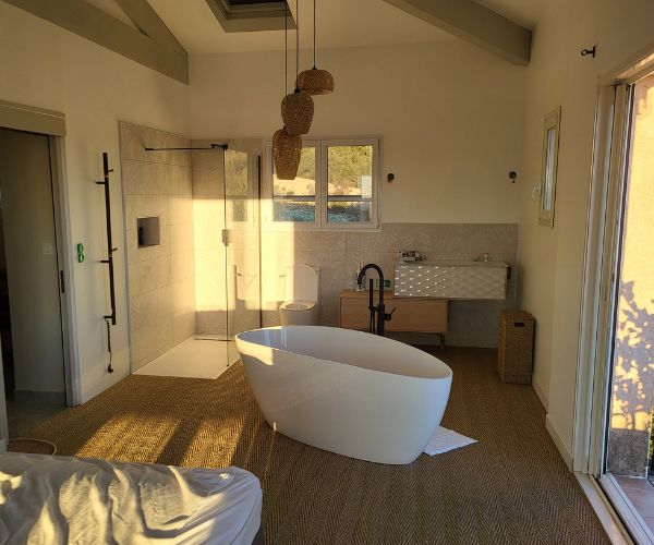 Salle de bains moderne avec baignoire îlot et douche italienne réalisée par FJ Maçonnerie à Béziers