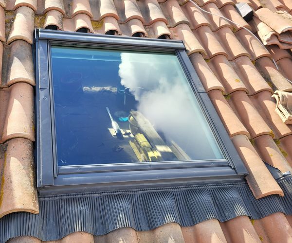 Fenêtre de toit Velux posée sur toiture en tuiles par FJ Maçonnerie à Béziers